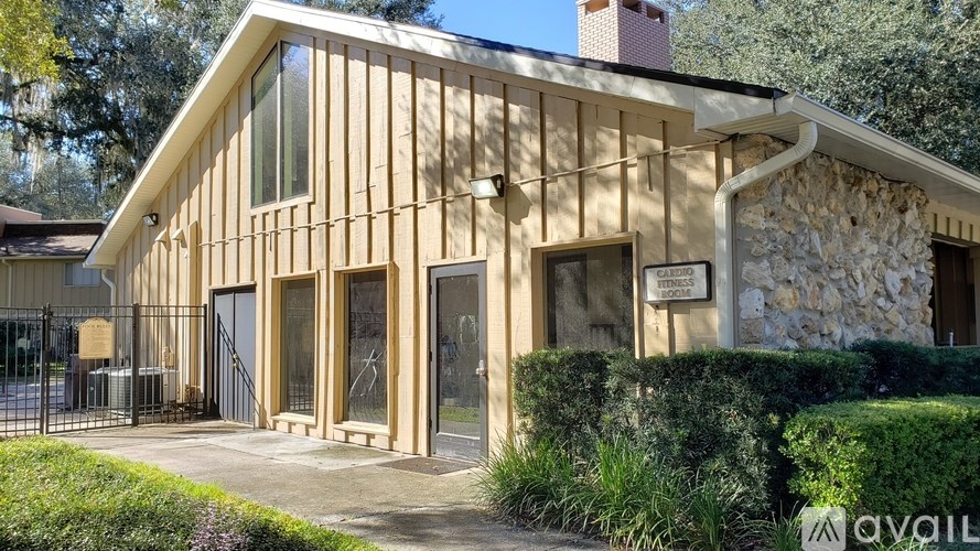 A modern house with a stone wall and wooden sidings.