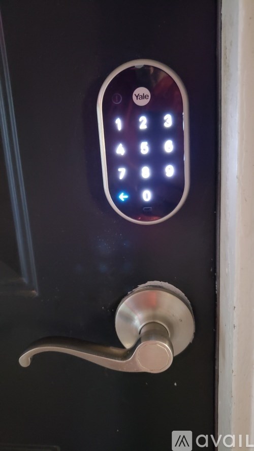 A Yale keypad is on a black door.