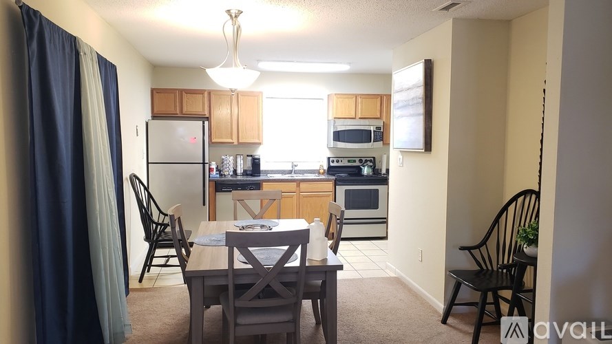 A kitchen with a dining table and chairs.