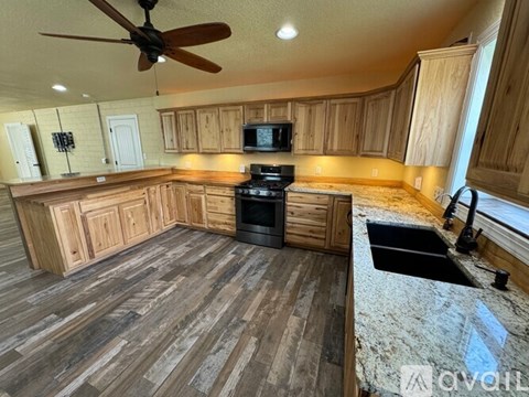 A kitchen with wooden cabinets and a black stove top oven.