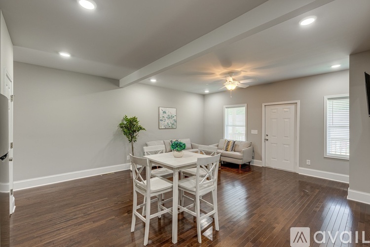 A dining room with a white table and chairs.