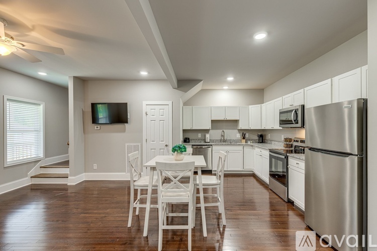 A modern kitchen with white cabinets and stainless steel appliances.