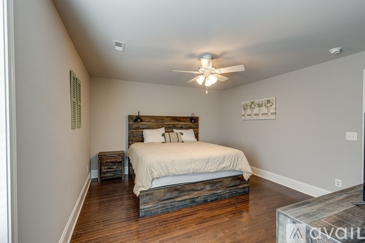 A bedroom with a bed, nightstand, and a ceiling fan.