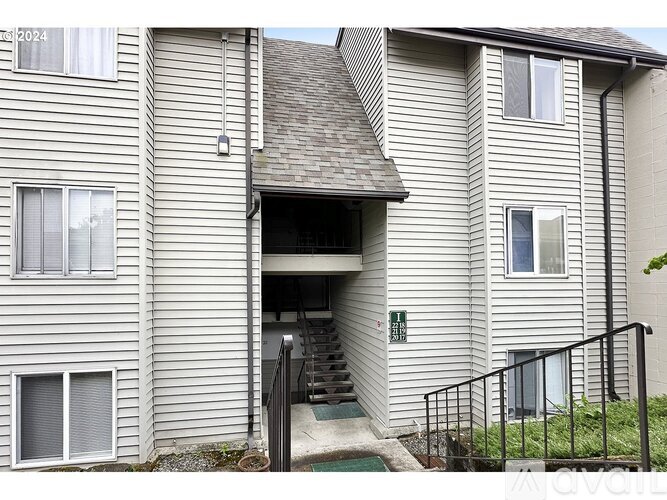 A building with a garage door open and a sign that says "AVAILABLE".