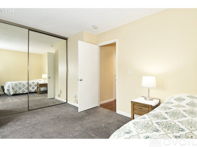 A bedroom with a bed, a nightstand, and a wardrobe.