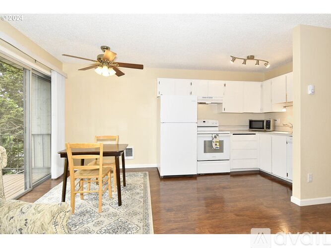 A kitchen with a table and chairs in front of a window.