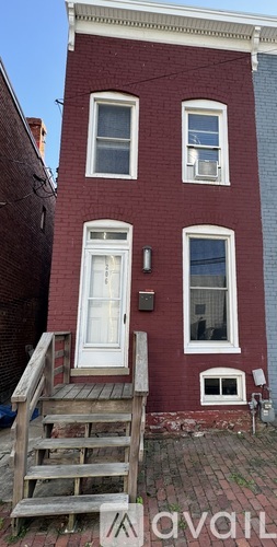A red brick house with a white door and windows.