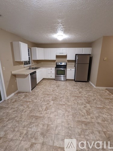 A kitchen with white appliances and beige cabinets.