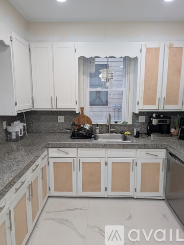 A kitchen with white cabinets and a black stove top.