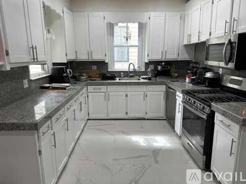 A kitchen with white cabinets and a black stove top.