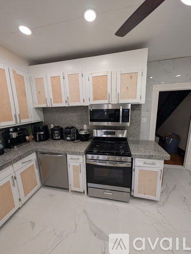 A white dishwasher and dryer stacked on top of each other in a small room.