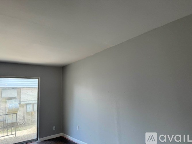 A room with a large window and a balcony outside.