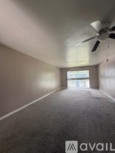 A room with a ceiling fan and a window with blinds.