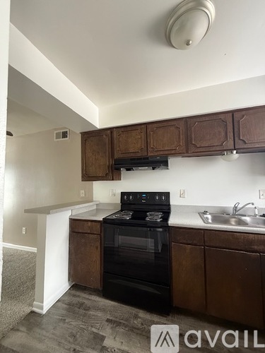 A kitchen with brown cabinets and a black oven.