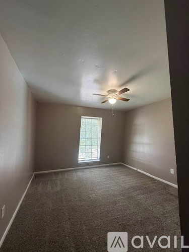 A room with a ceiling fan and a window.