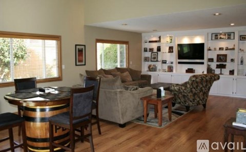 A living room with a couch, chair, and a television on the wall.