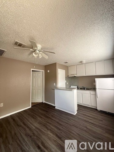 A kitchen with white cabinets and a white fridge.