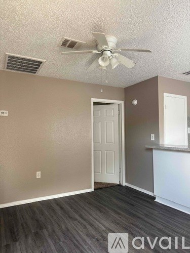 A room with a ceiling fan and a door.