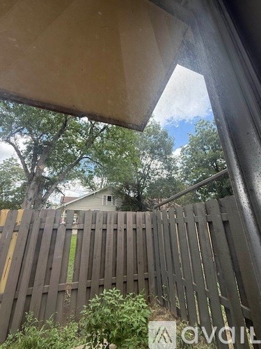 A wooden fence is in front of a house.