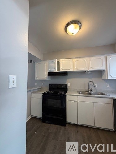 A kitchen with white cabinets and a black oven.