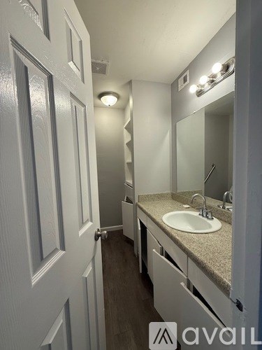A bathroom with a sink, mirror, and light fixture.