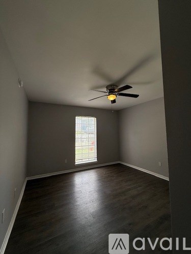 A room with a ceiling fan and a window.