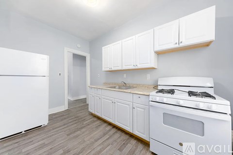 A kitchen with white appliances and cabinets.
