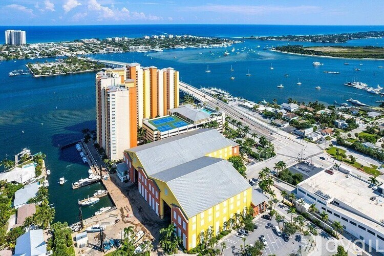 A large building with a yellow and white facade is situated by a body of water.