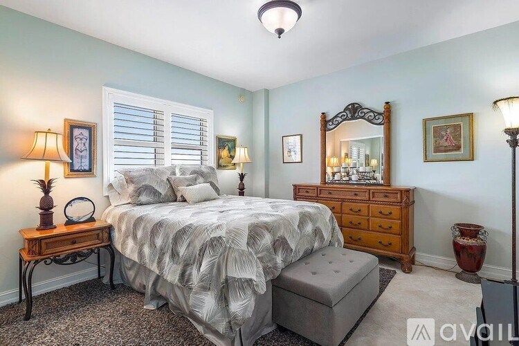 A bedroom with a bed, dresser, and mirror.