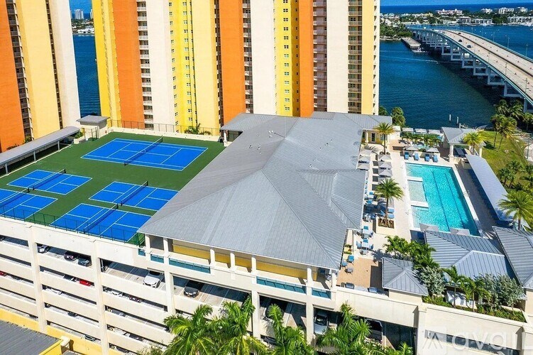 A hotel with a tennis court and a pool.