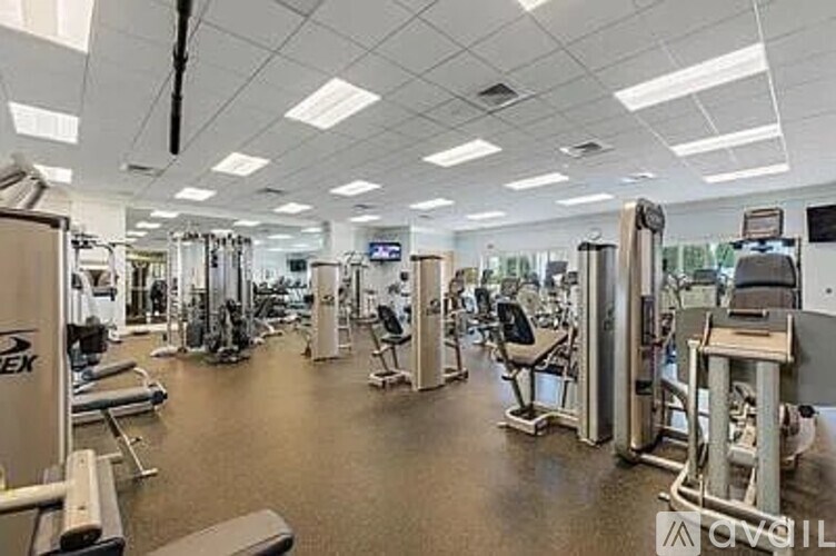 A gym with a variety of equipment including treadmills, weights, and exercise machines.