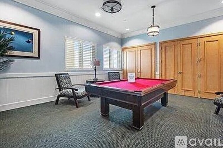 A room with a pool table and a chair.
