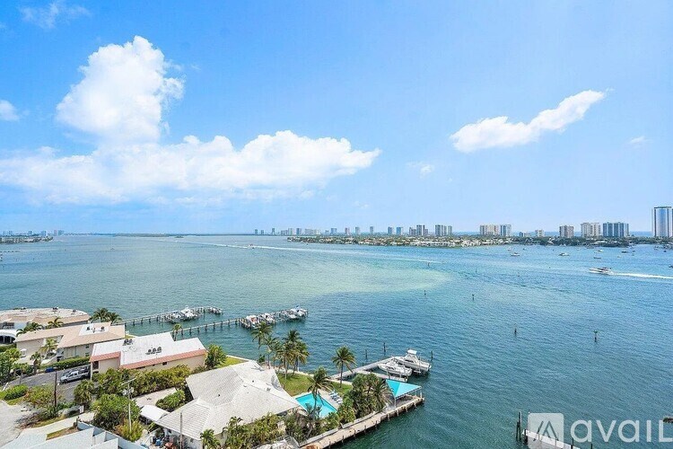 A view of a waterfront area with boats docked and buildings in the distance.