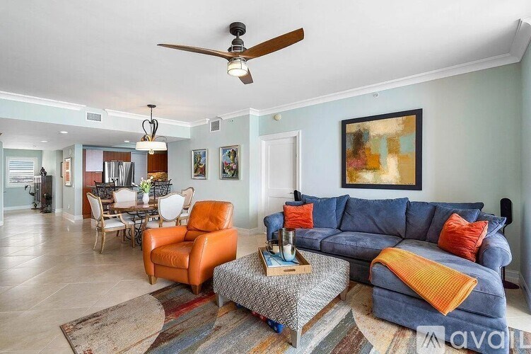 A living room with a blue couch and orange chairs.