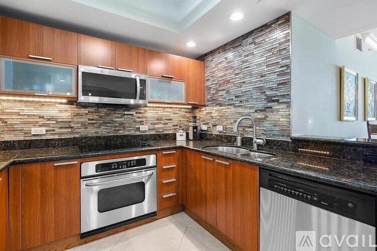 A kitchen with wooden cabinets and a stone backsplash.