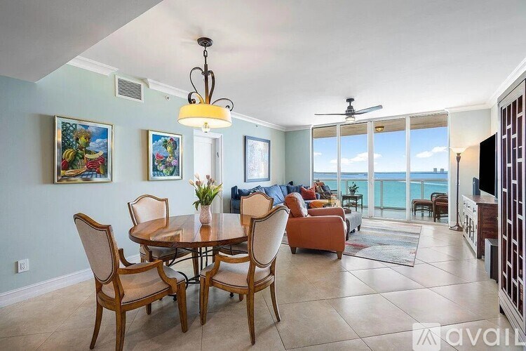 A dining room with a table set for six with a view of the ocean.