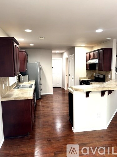 A kitchen with dark wood cabinets and a white refrigerator.