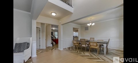 A spacious living room with a dining table and chairs.
