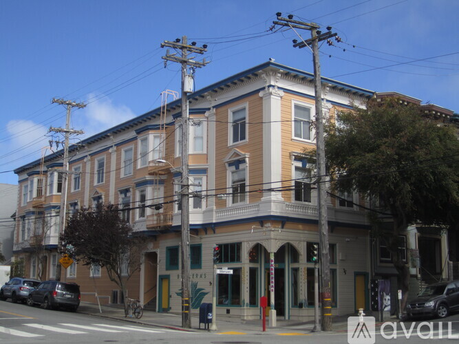 A street view of a building with cars parked in front.