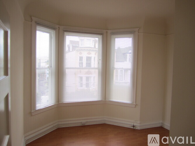 A room with a window and a wooden floor.