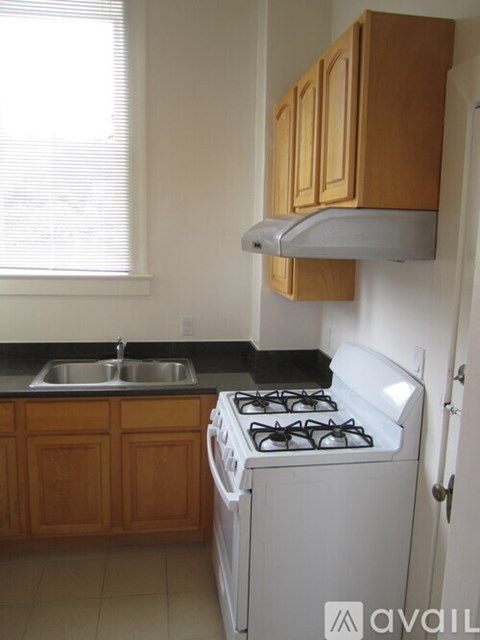 A kitchen with a white stove and a window.