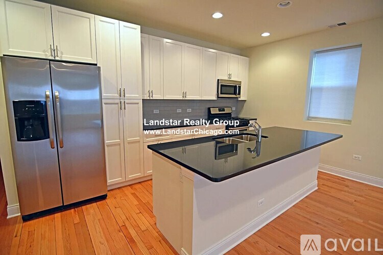 A kitchen with a black countertop and stainless steel appliances.
