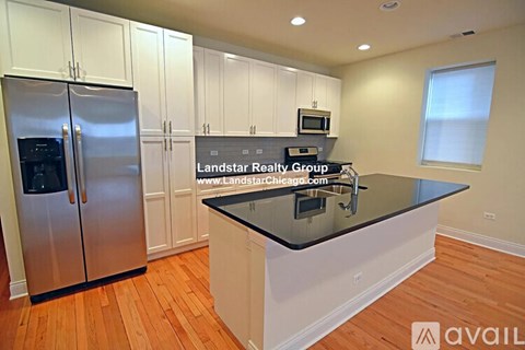 A kitchen with a black countertop and stainless steel appliances.