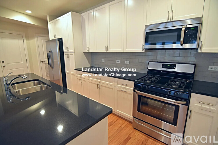 A kitchen with a stove, sink, and cabinets.