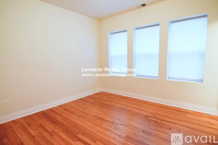 A room with wooden flooring and three windows is available for rent.