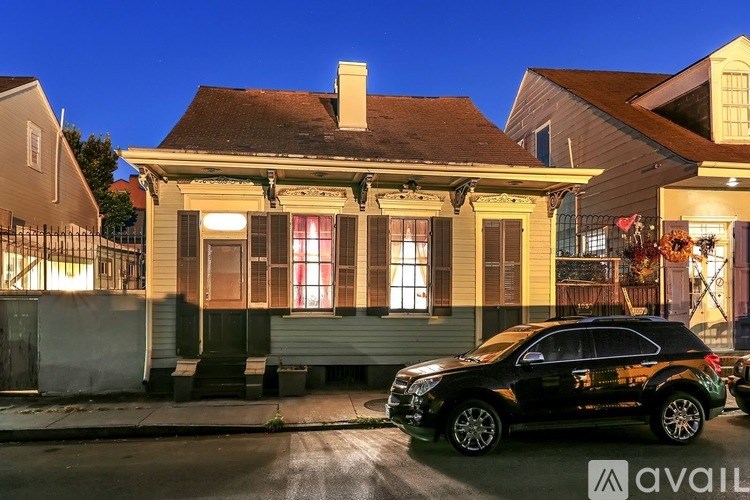 A house with a black car parked in front of it.