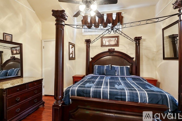 A bedroom with a large bed and a chandelier.