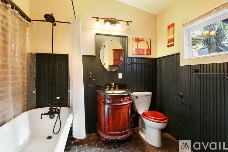 A bathroom with a red sink and a white toilet.
