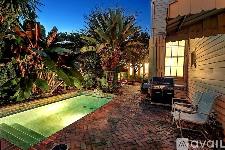 A backyard with a pool and patio furniture.