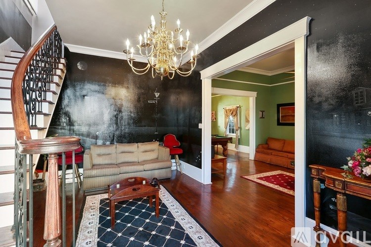 A living room with a couch, a coffee table, and a chandelier.